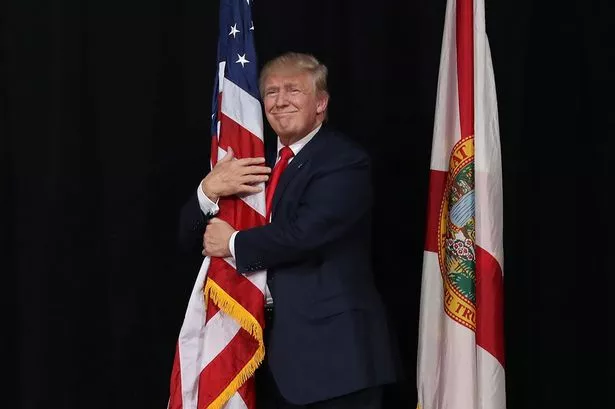 Donald-Trump-hugging-American-flag-MAIN.jpg