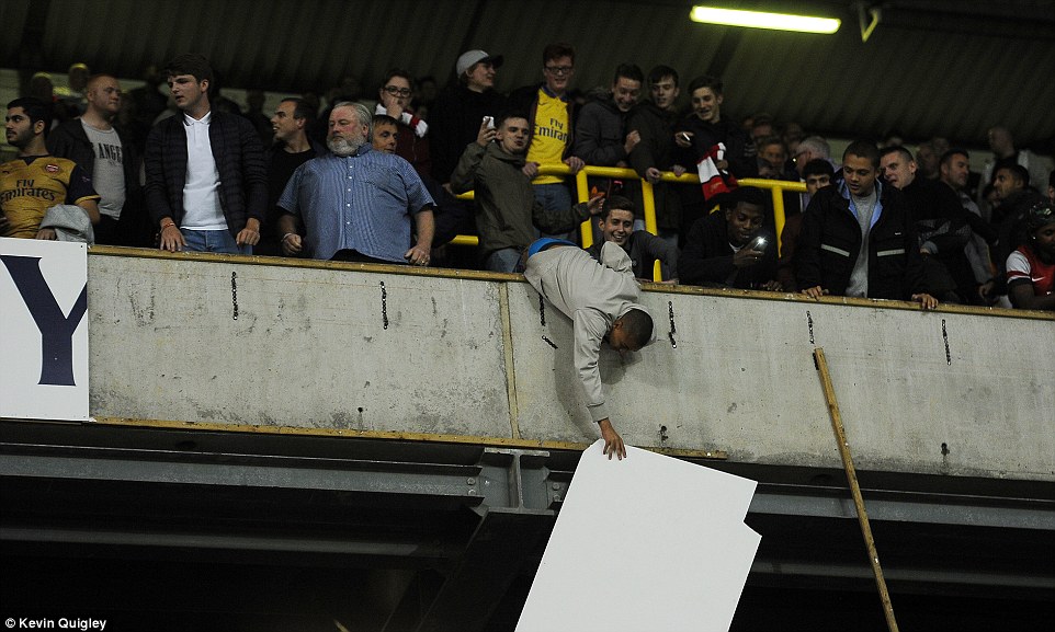 2CB0D64F00000578-3246829-One_Arsenal_fan_holds_a_piece_of_the_signage_while_dangling_over-a-67_1443045878144.jpg